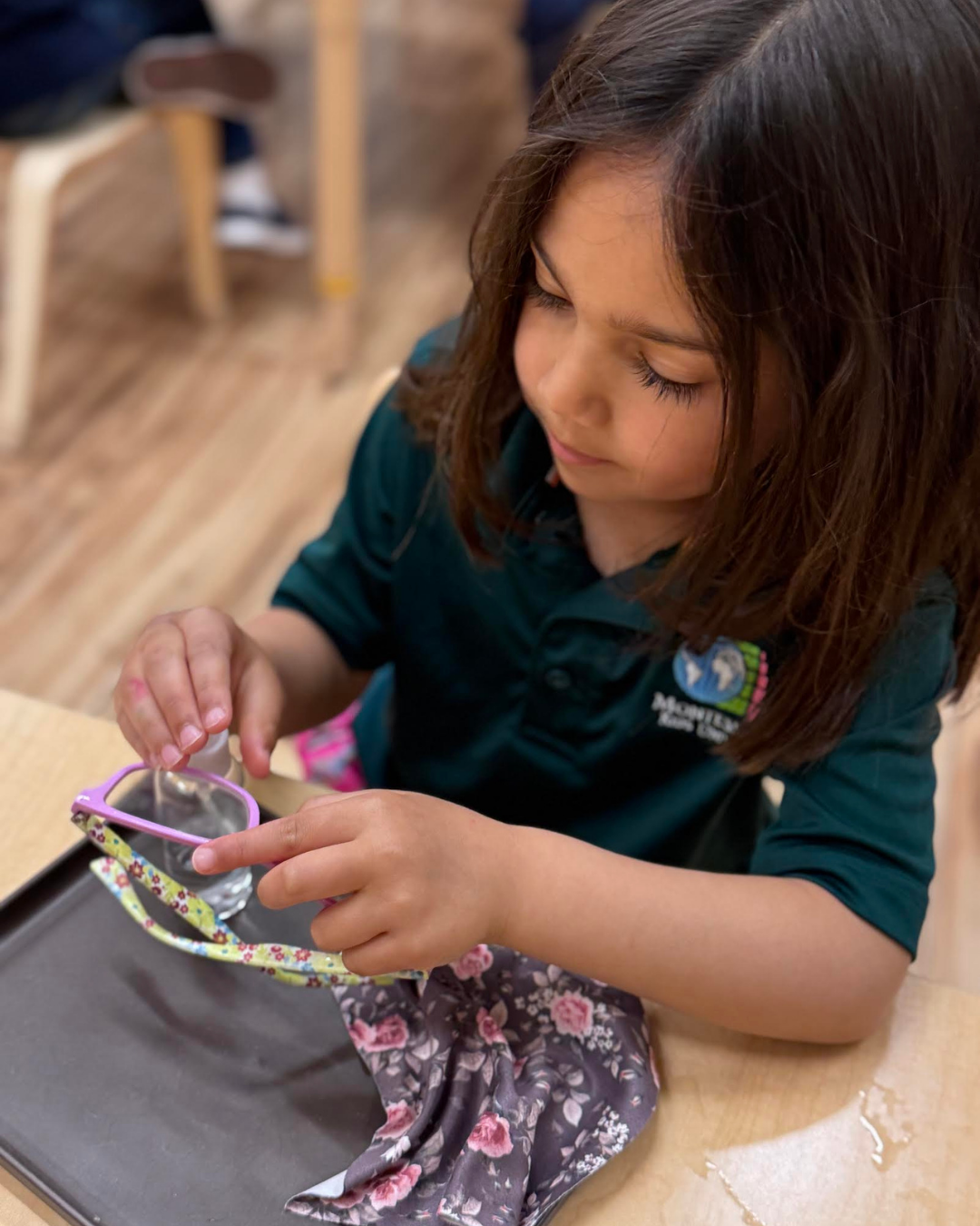 Child cleaning glasses independently