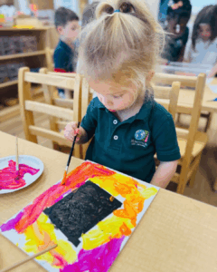 Child painting art in classroom