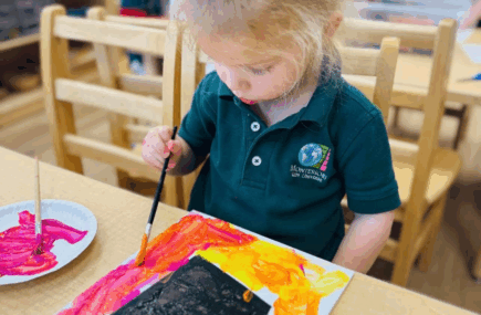 Child painting art in classroom